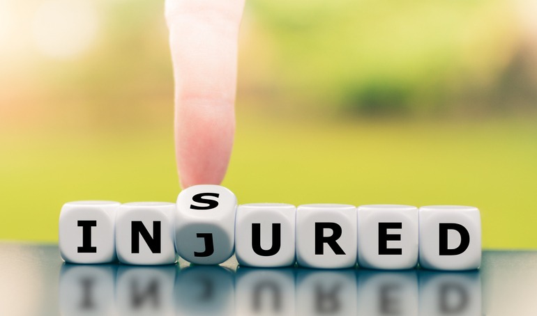 Be insured when injured. Hand turns a dice and changes the word injured to insured.