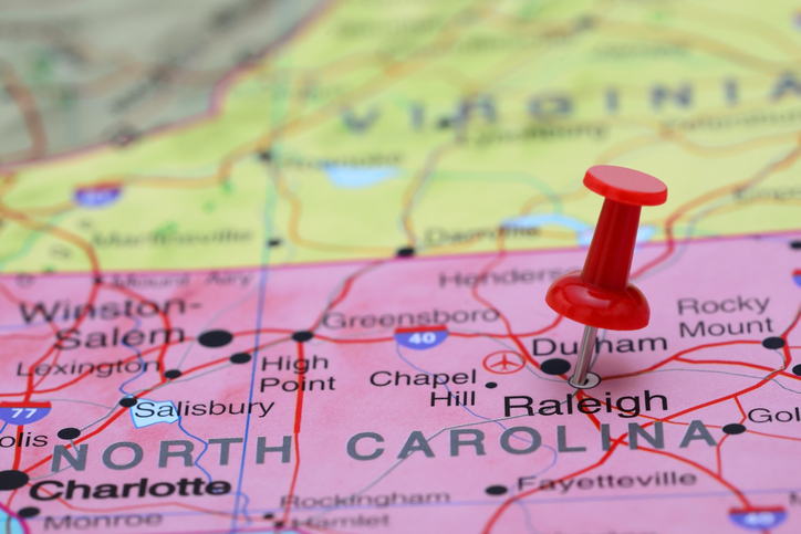 Photo of pinned Raleigh on a map of USA.